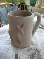 unfired clay mug, with relief of zebra on side